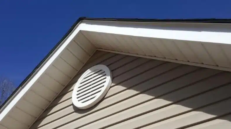 A white rectangular vent on the side of a house, known as a gable end vent