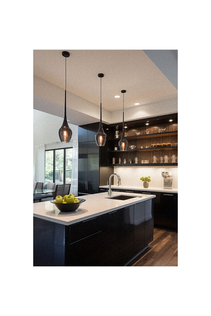 A modern kitchen with black cabinets and wood floors.