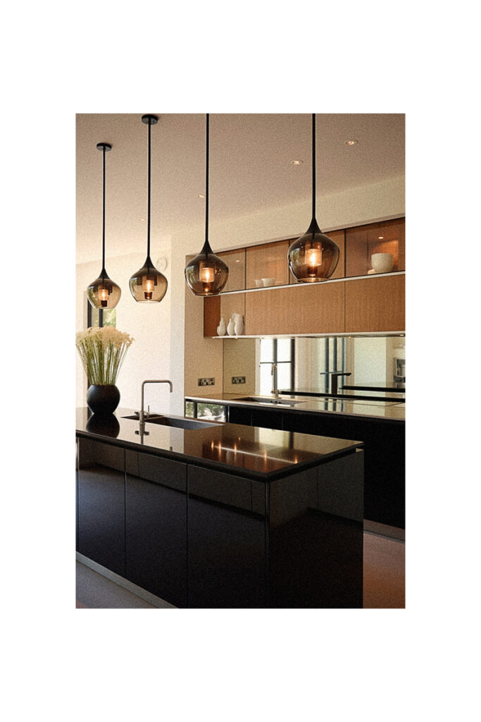 A modern kitchen with black cabinets and black counter tops.