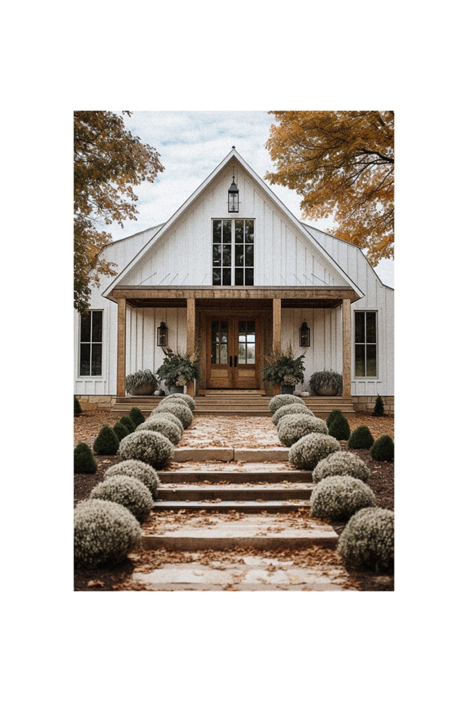 A white farmhouse with steps decorated with fall decor leading up to the front door.