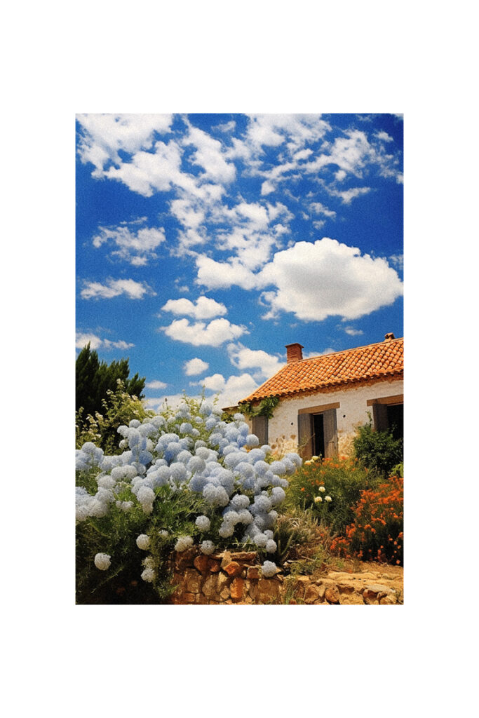 A picturesque French Country Cottage under a blue sky with white clouds.