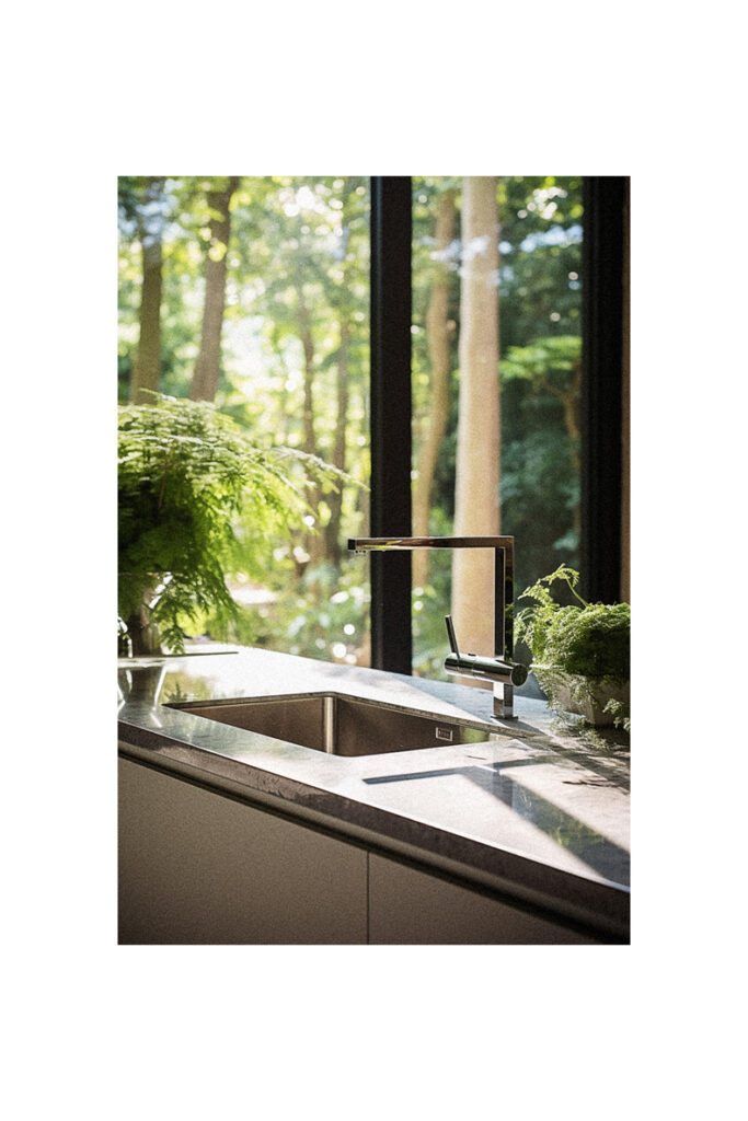 A kitchen with a large window and plants in front of it.