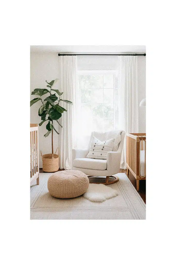A white baby room with a plant and a chair, perfect for nursery room inspiration.