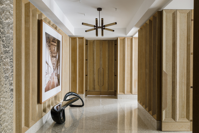 A hallway with wooden paneling and a large painting.