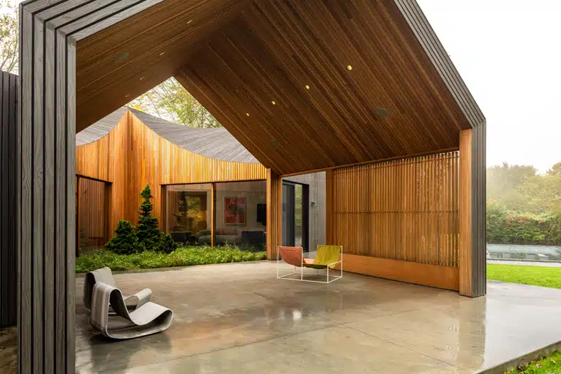 A modern house with wooden cladding and a patio.