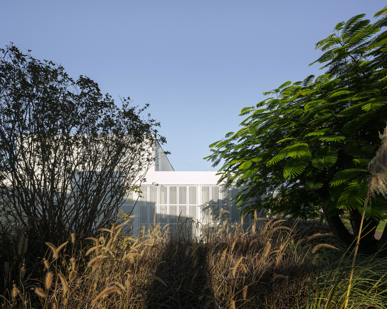 An image of a white building in a grassy area.