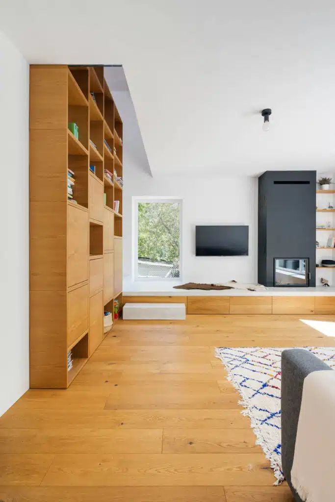 A modern living room with wooden shelves and a tv.