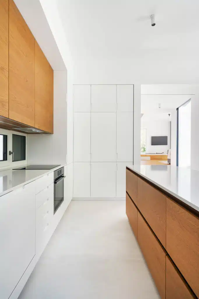 A modern kitchen with white cabinets and wooden counter tops.