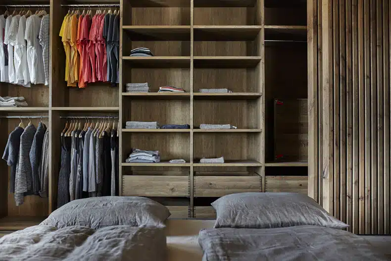 A bedroom with a closet full of clothes.