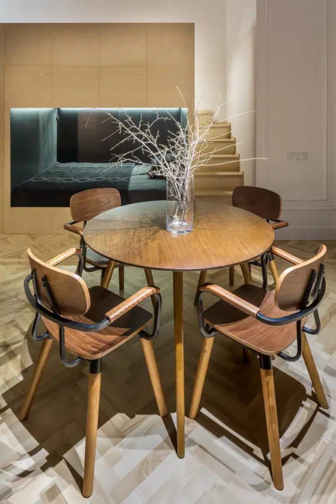 A modern dining room with a wooden table and chairs in the Smart 60 Apartment.