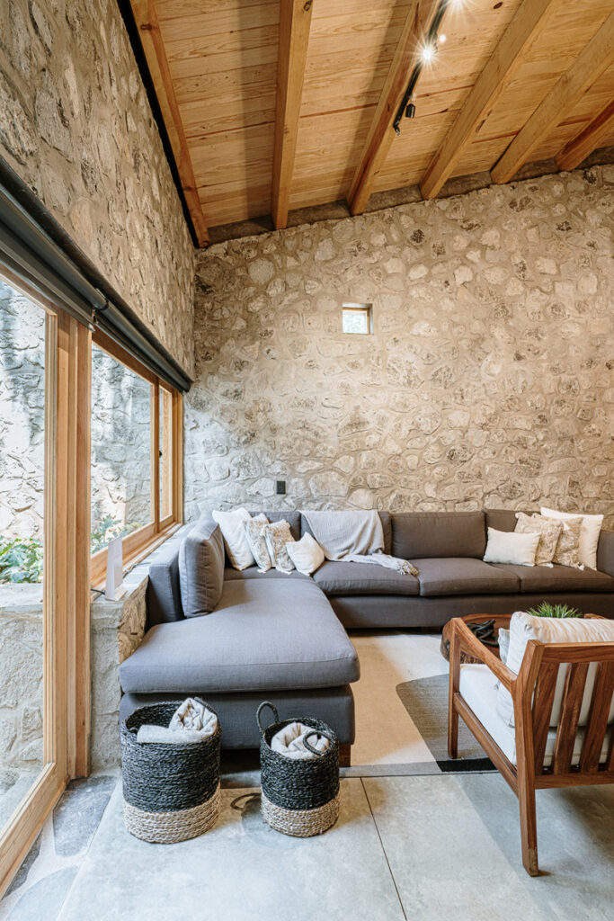A living room in Petraia House with stone walls and a couch.