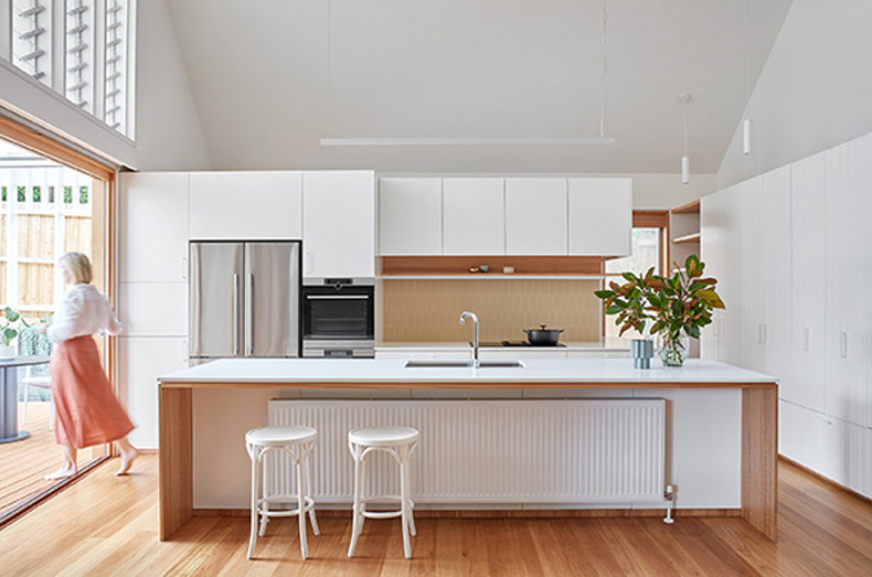 Twin Peaks House by Mihaly Slocombe features a white kitchen with wooden floors.