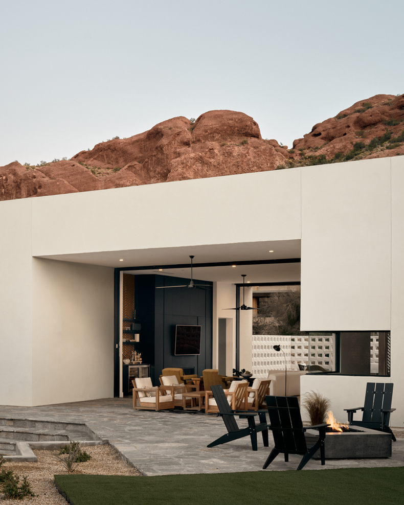 A modern home in the desert with a fire pit.