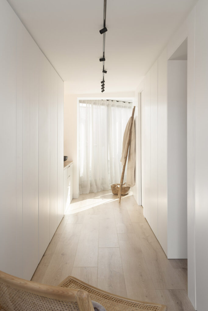 Citric House, a hallway with white cabinets and a wooden chair, designed by Susanna Cots Interior Design.