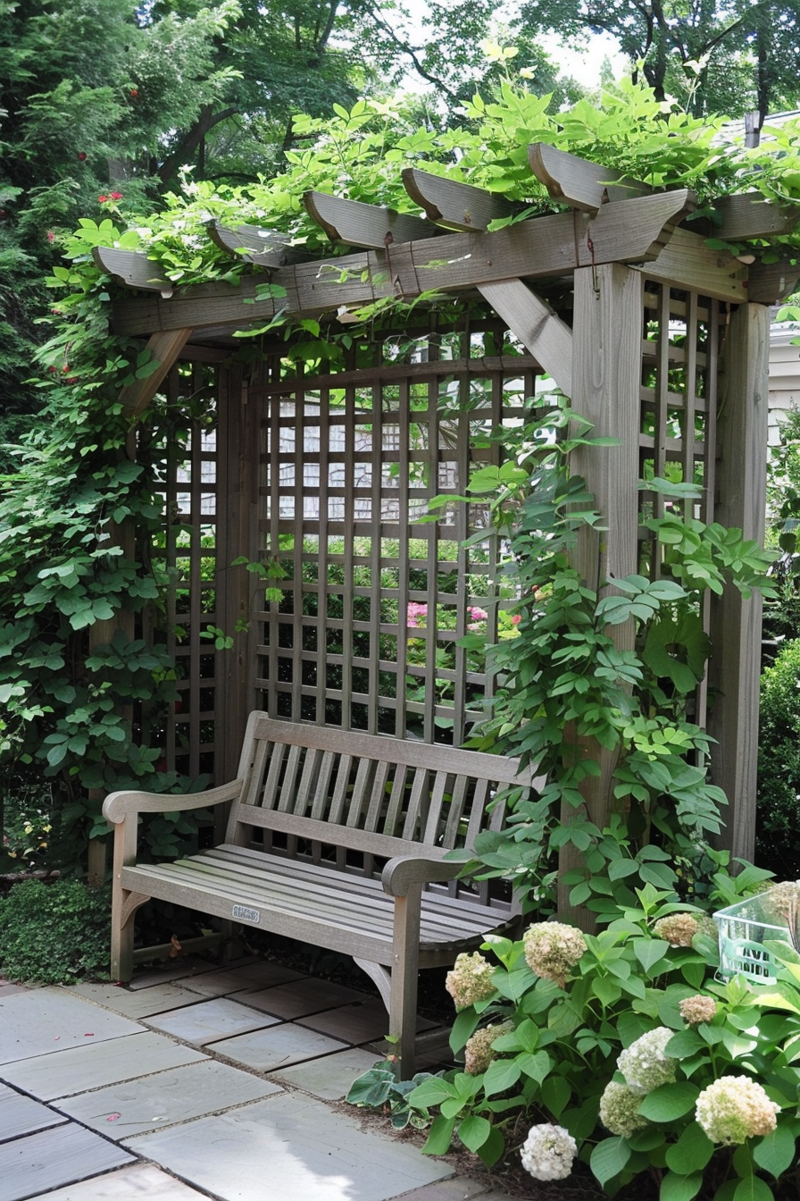 Wooden bench under a pergola covered with green vines and leaves, surrounded by lush garden foliage.