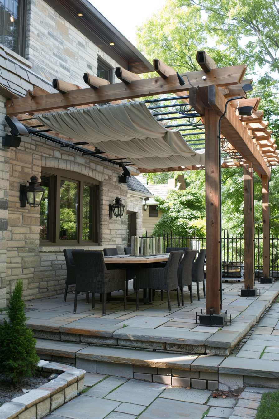 Elegant patio with a wooden pergola, retractable canopy, outdoor dining set, and stone flooring surrounded by greenery.