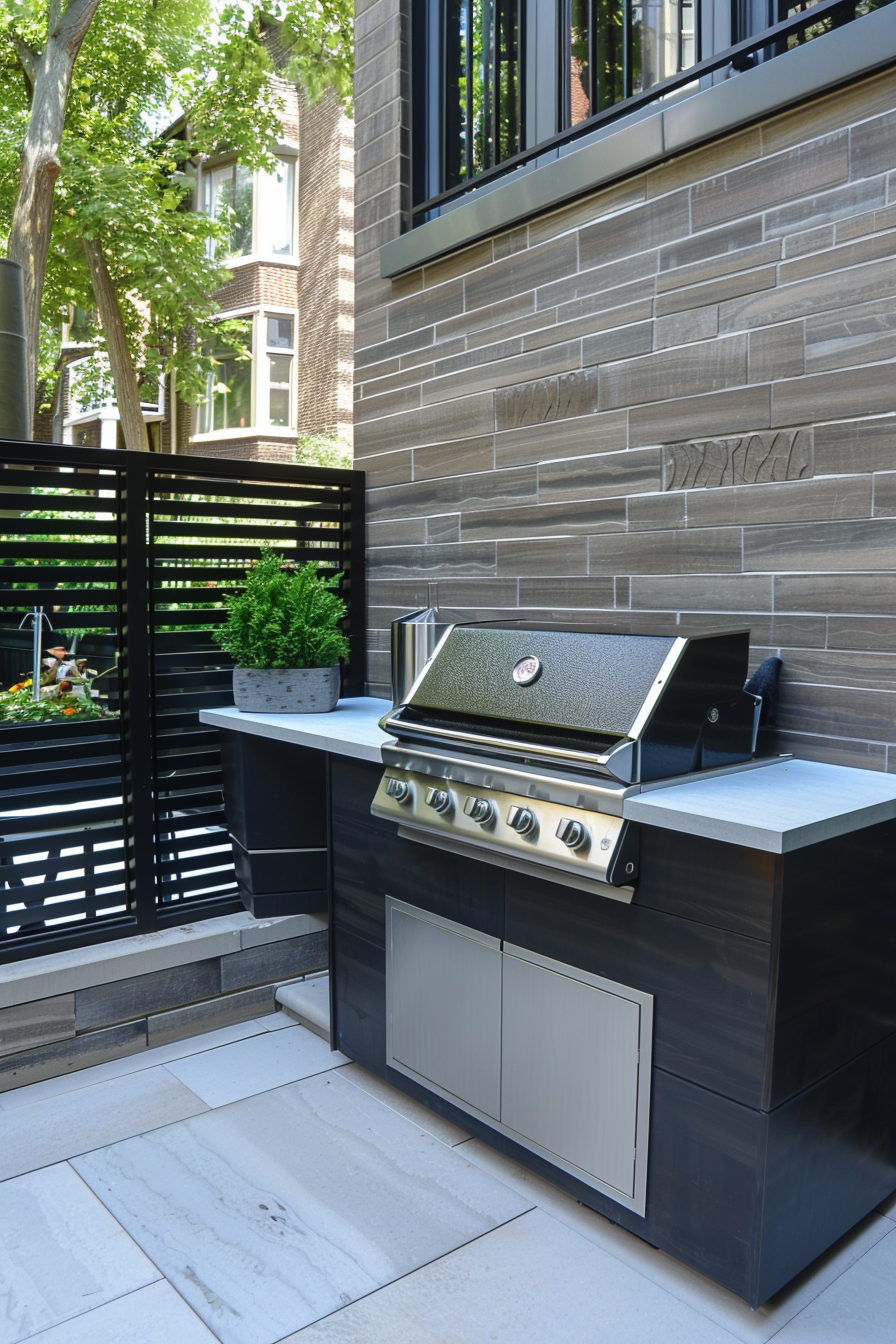 Modern outdoor kitchen setup with a built-in grill and storage on a patio, surrounded by privacy screens and greenery.