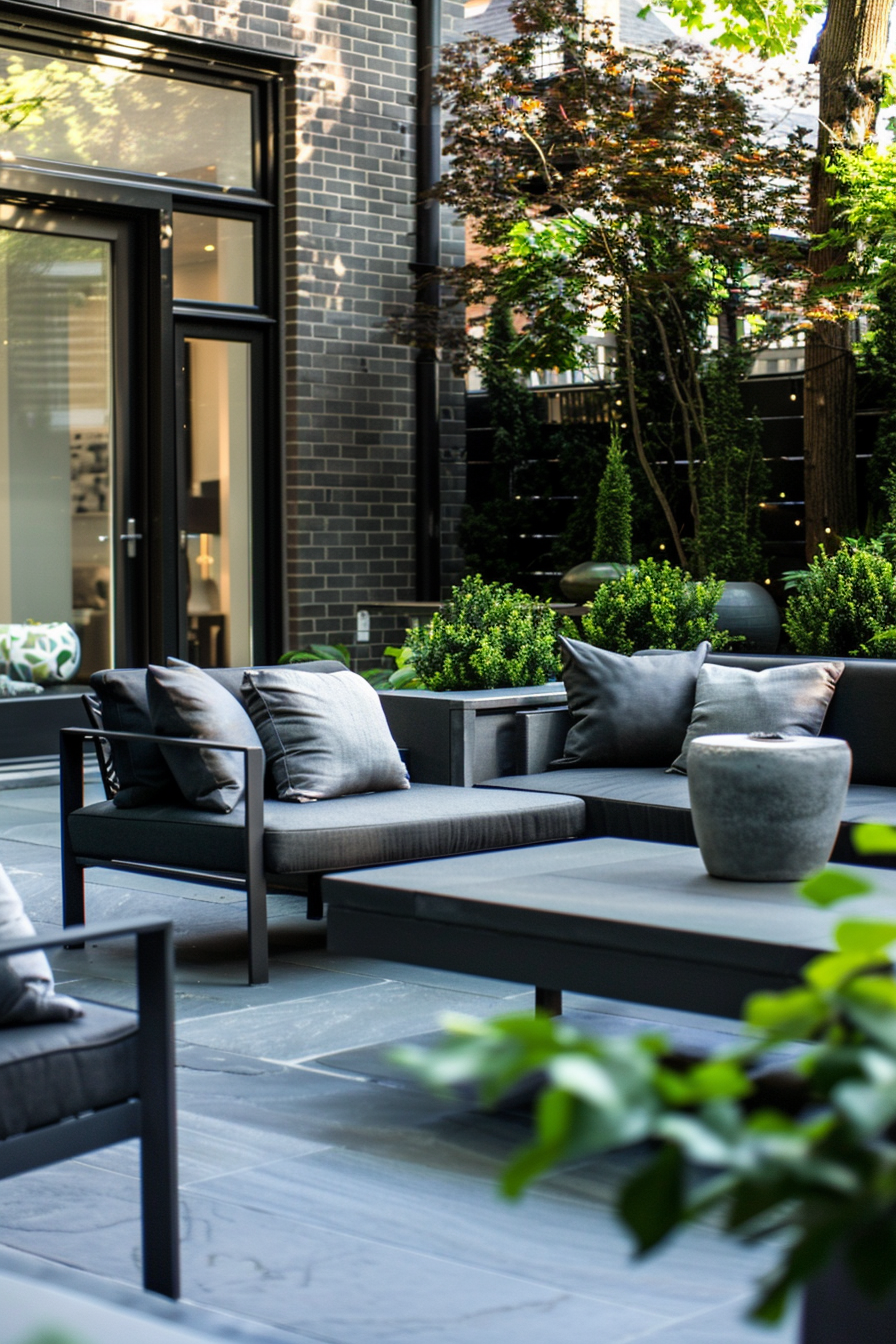 Outdoor patio with modern furniture, potted plants, and black brick walls, creating a cozy urban garden space.