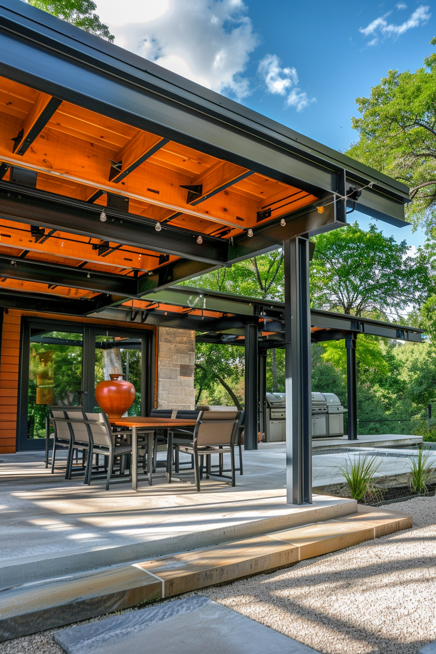Modern outdoor patio area with dining set, barbecue grill, and a wooden ceiling with recessed lights, surrounded by green trees.