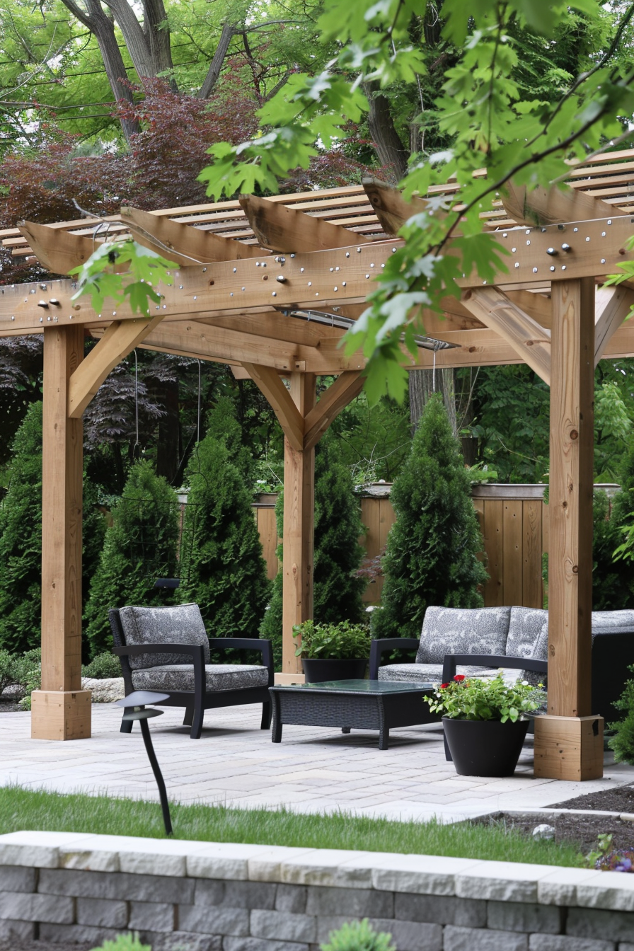 A serene garden patio with a wooden pergola adorned with string lights, surrounded by lush greenery and furnished with comfortable chairs.
