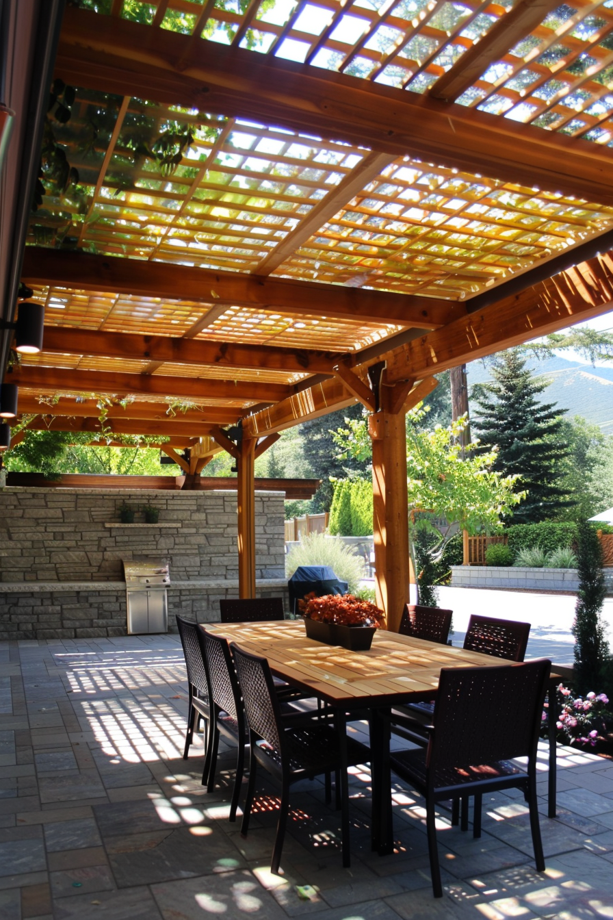 Outdoor patio area with wooden pergola, dappled sunlight, dining table set, and a built-in grill station.