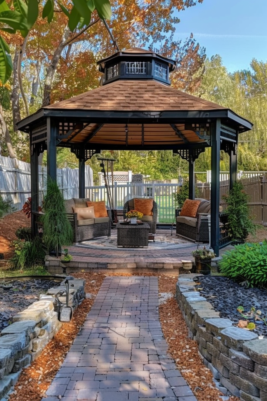 A serene backyard garden with a paved path leading to a gazebo, surrounded by trees with autumn foliage.