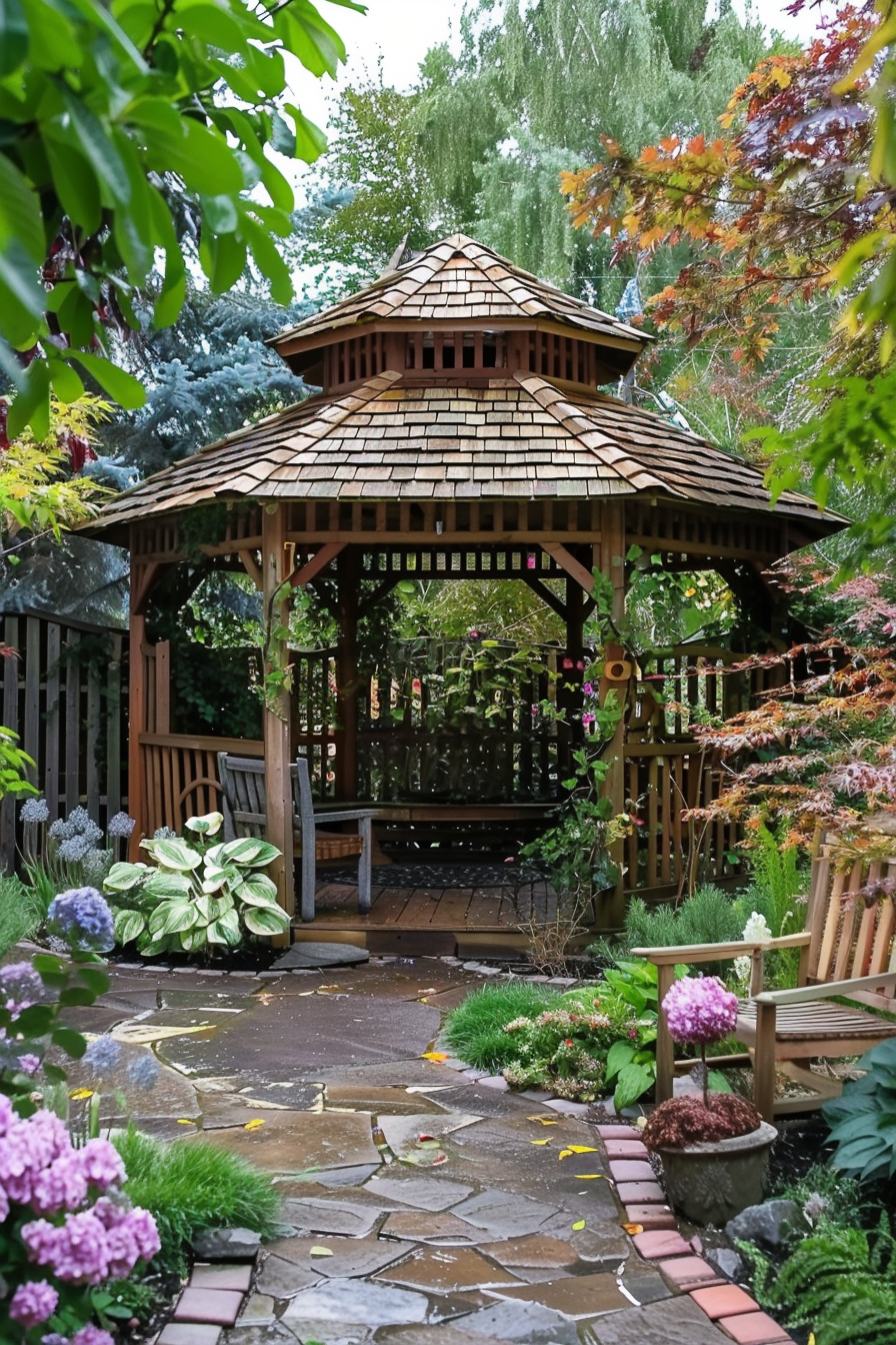 Wooden gazebo in a lush garden with stone path, surrounded by vibrant plants and trees.