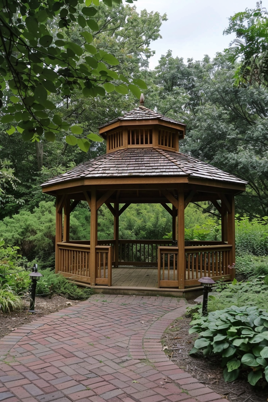 ALT: A wooden gazebo sits on a brick pathway surrounded by lush greenery in a tranquil garden setting.