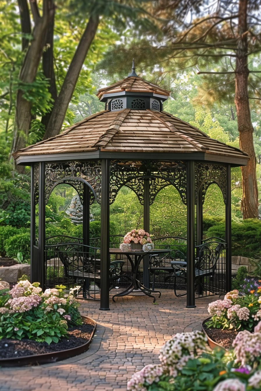 Elegant garden gazebo surrounded by lush greenery, with wrought-iron furniture and blooming flowers on a brick patio.