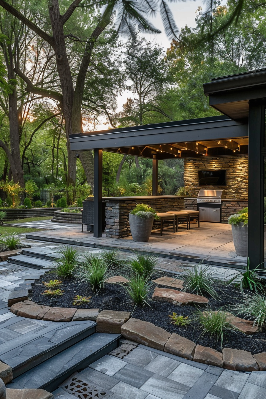 ALT: A modern outdoor kitchen pavilion with stone accents and string lights at dusk, surrounded by landscaped garden and paved walkways.