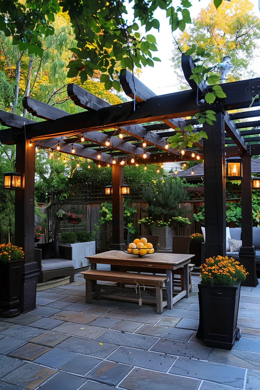 Cozy garden patio with a pergola adorned with string lights, wooden furniture, and decorative plants at twilight.