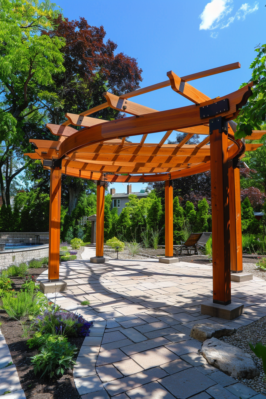 Wooden pergola in a garden with stone pathway, surrounded by greenery and a clear blue sky.