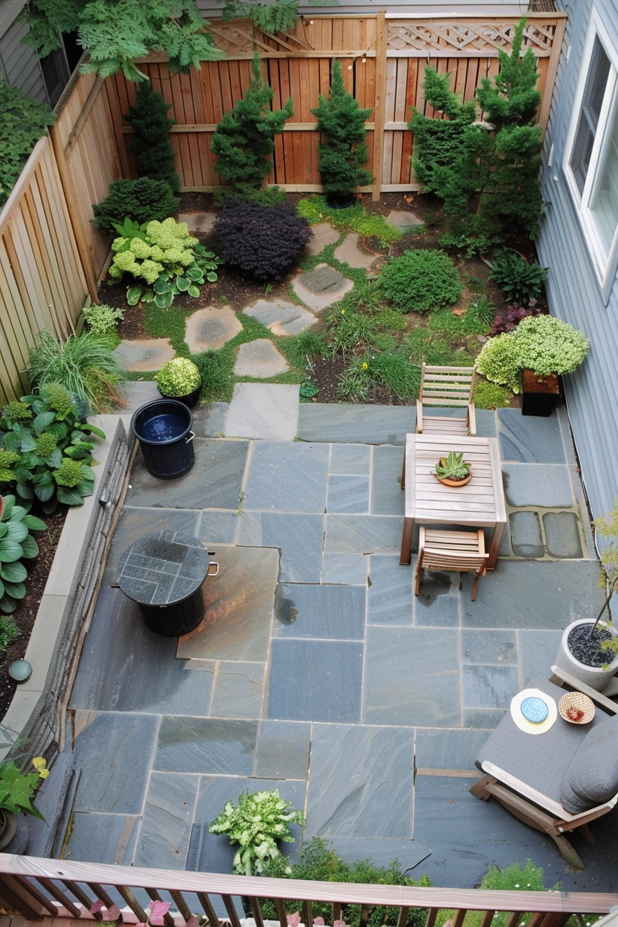 Overhead view of a cozy backyard with slate patio, wooden furniture, lush greenery, and a stepping stone path.