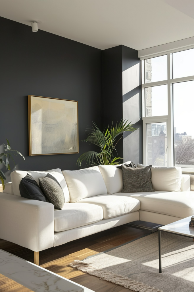 Modern living room with a white sectional sofa, black walls, large windows, and a framed artwork above the couch.