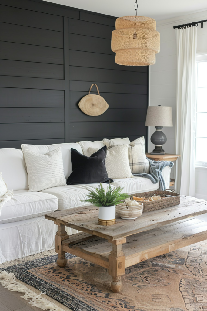 A cozy living room with a white sofa, rustic wooden coffee table, wicker pendant lamp, and decorative accents against a dark-paneled wall.
