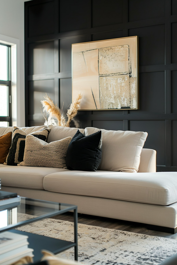 Modern living room with a beige sofa, decorative pillows, abstract art on a black paneled wall, and a glass coffee table.