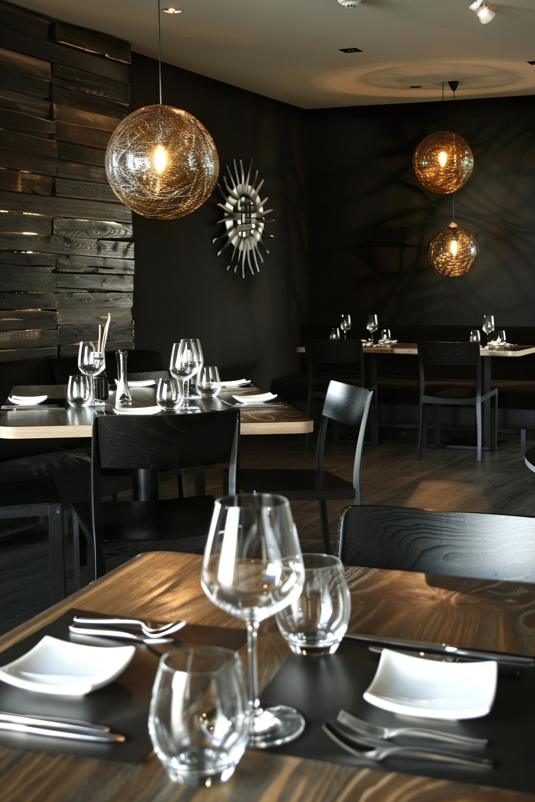 Elegant restaurant interior with modern lighting, dark wooden tables set with glassware and plates.