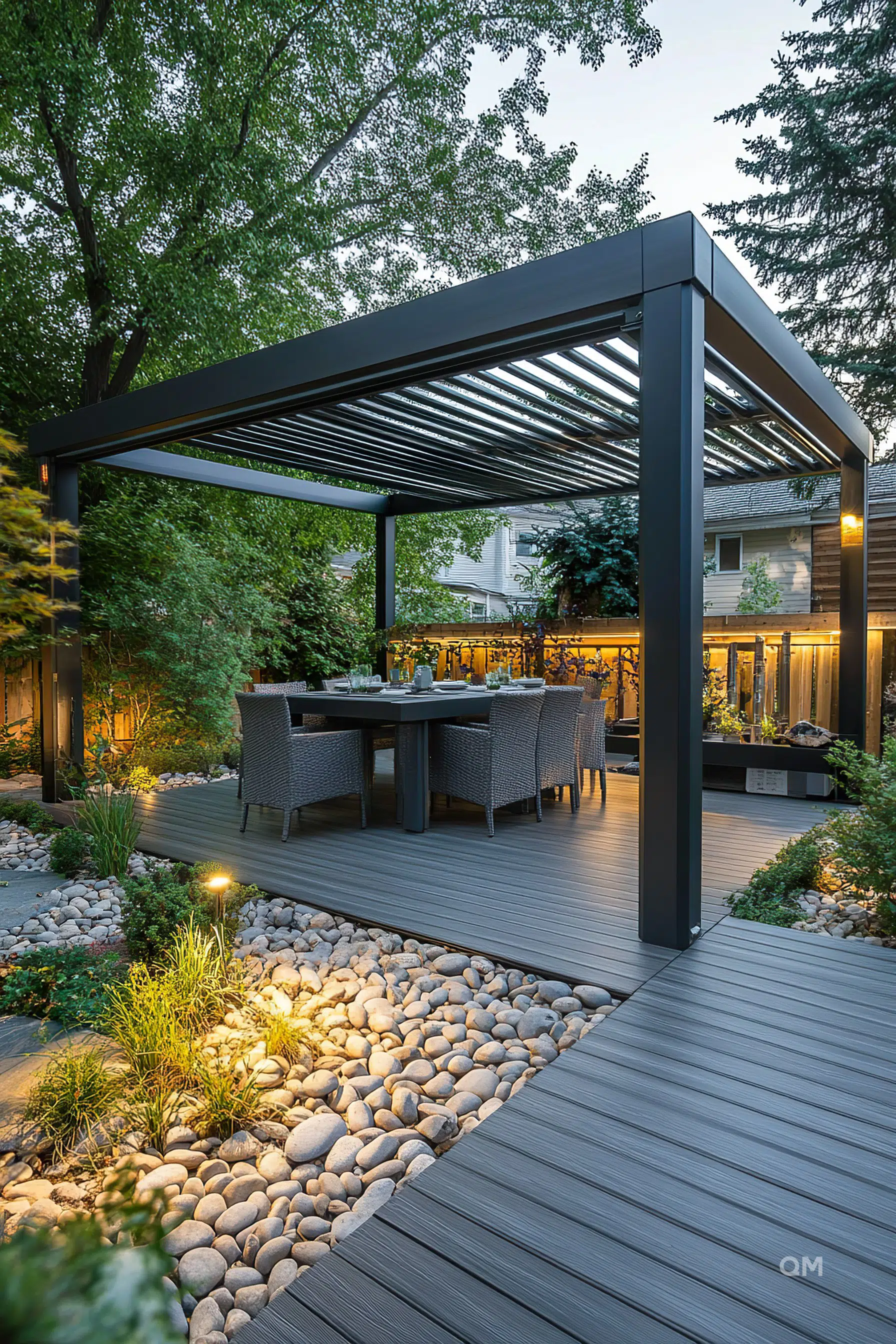 Outdoor dining area with a modern pergola, surrounded by trees and landscaping, illuminated by soft garden lighting at dusk.
