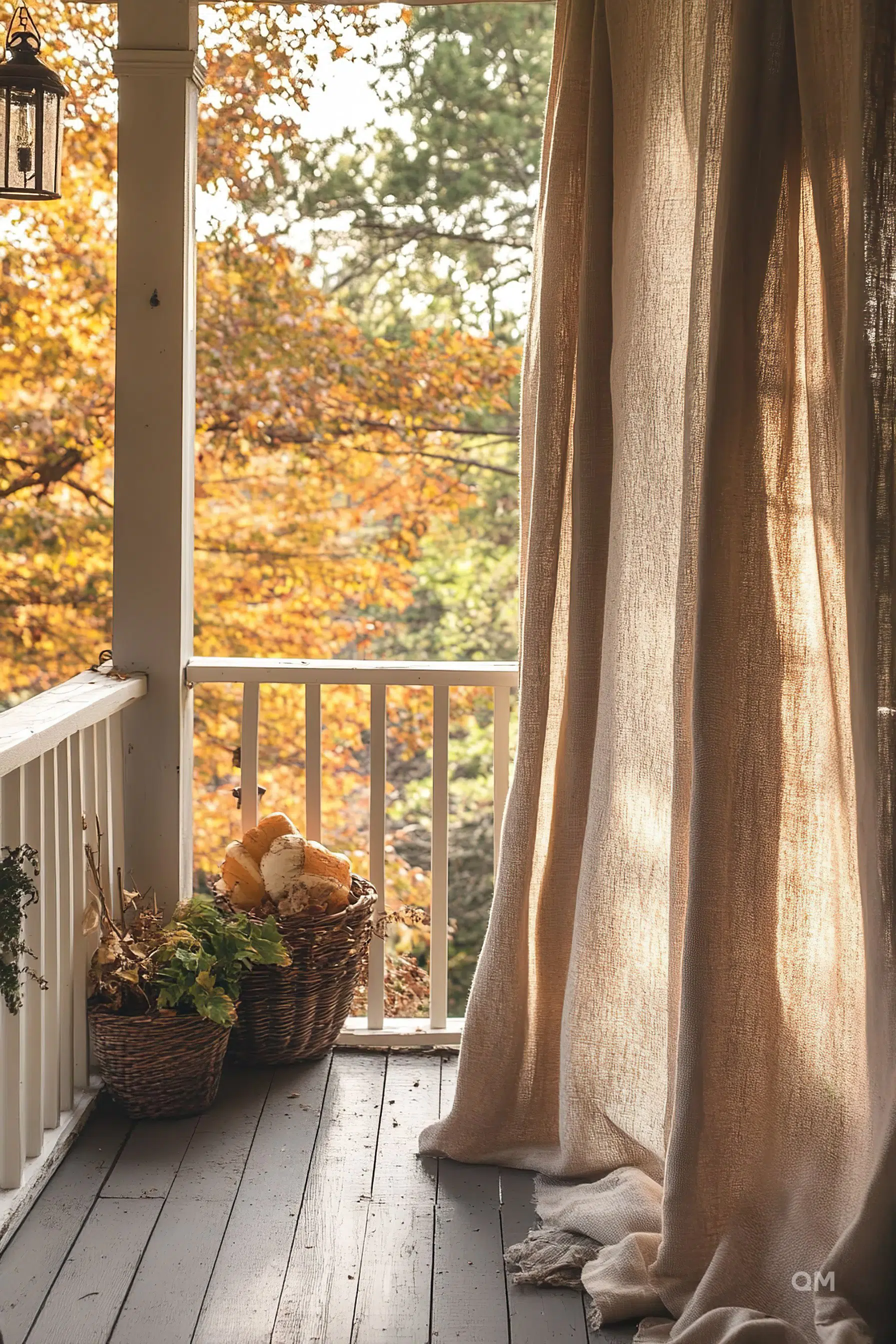 Cozy autumn balcony with a long beige curtain, wicker baskets with plants and bread, overlooking trees with fall foliage.