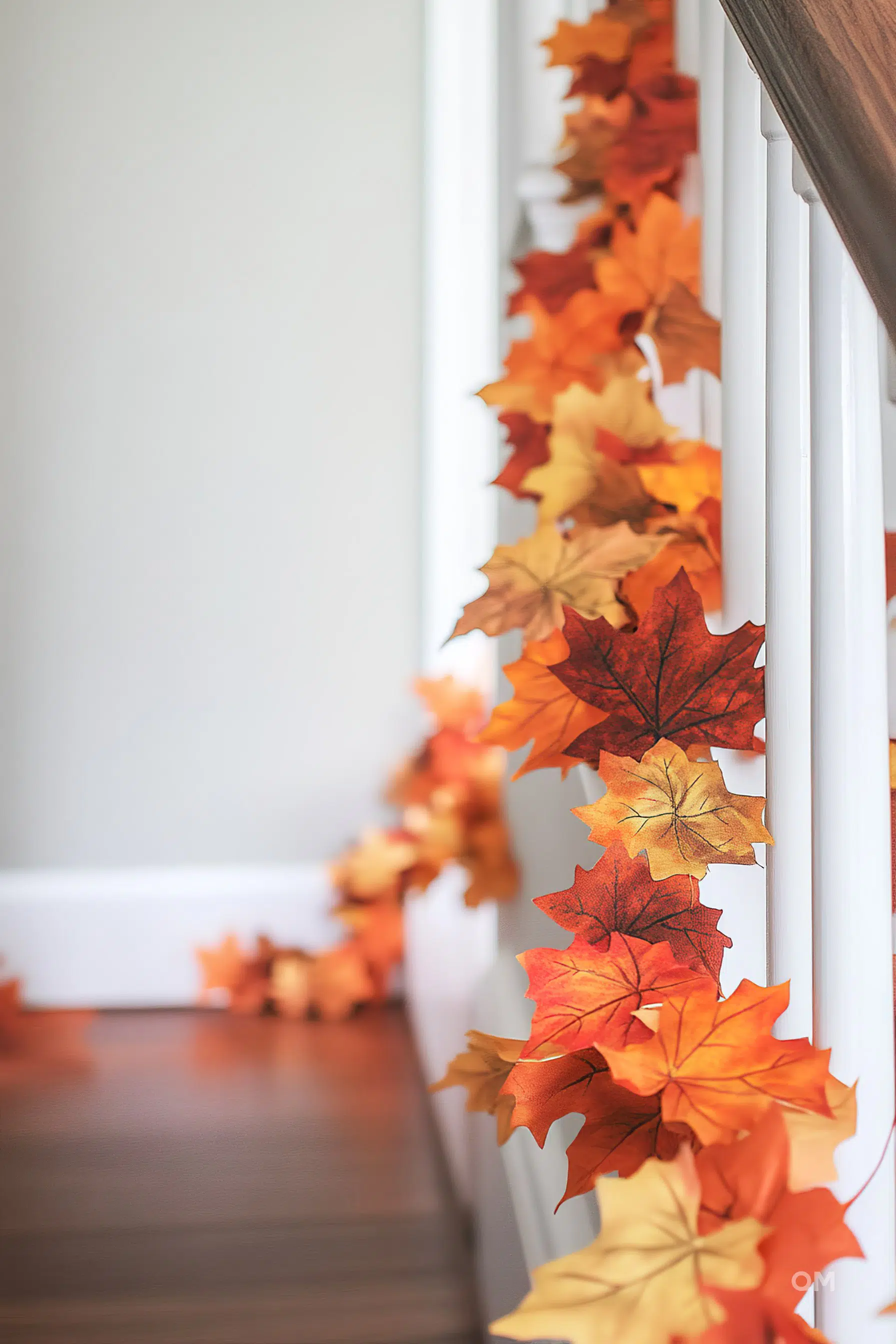 A staircase adorned with a string of colorful autumn leaves, adding a cozy, seasonal touch to the home decor.