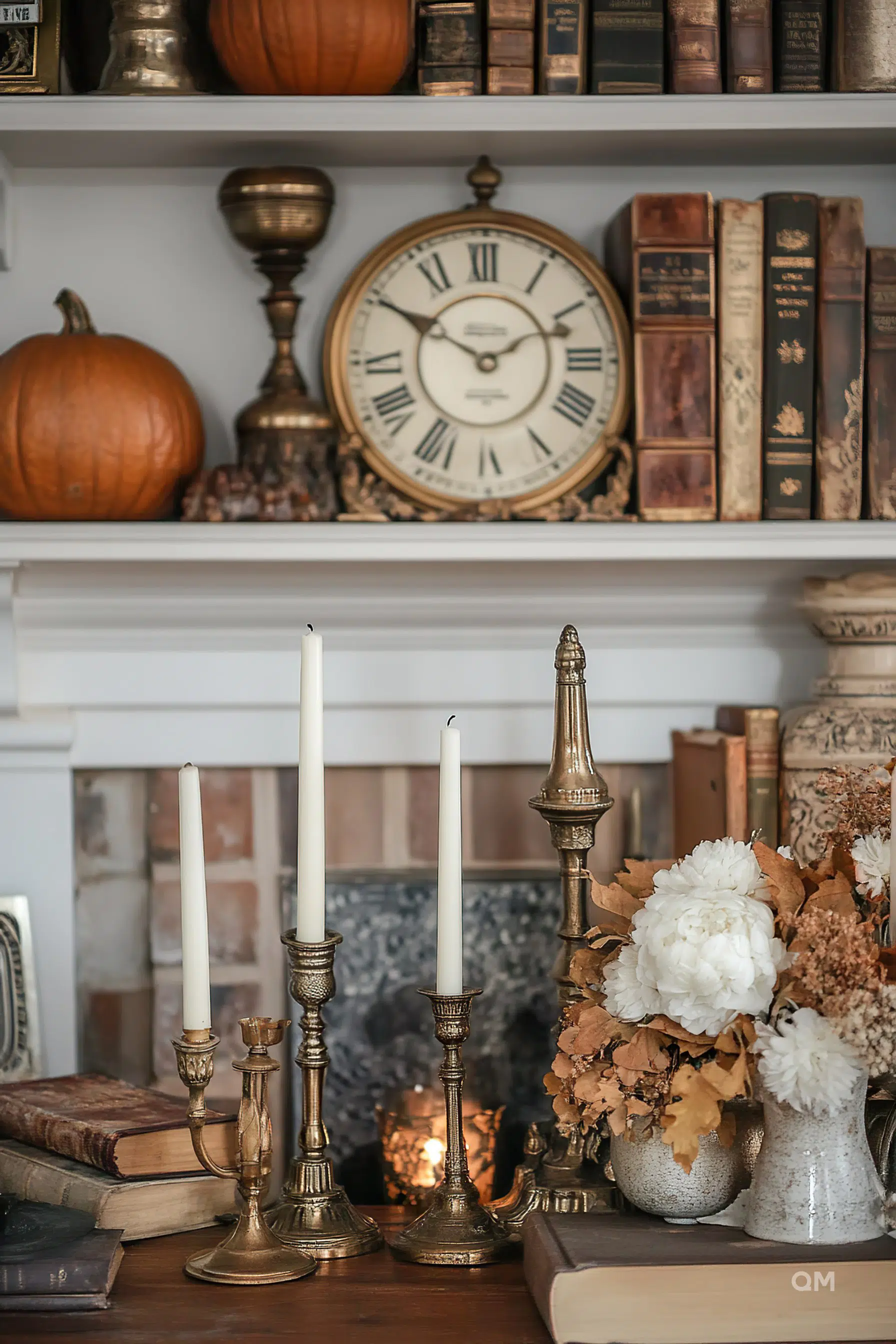 Cozy interior with a classic mantelpiece adorned with candles, a clock, pumpkins, books, and autumnal flowers.