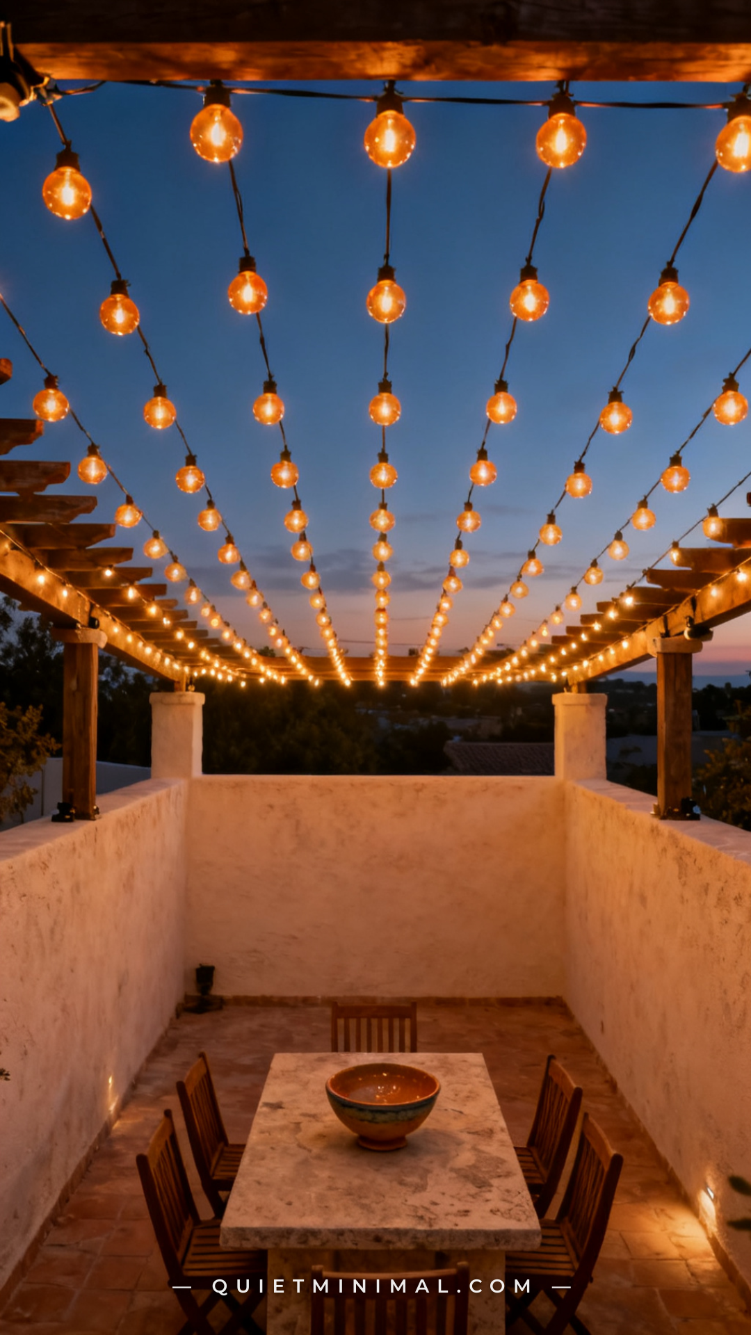 A wide overhead-perspective photograph of a Mediterranean-style courtyard patio with complete string light canopy covera