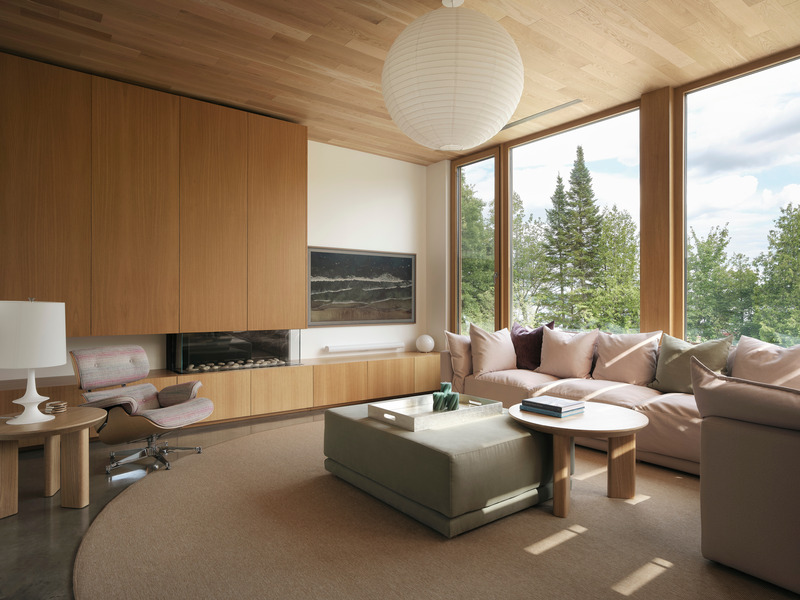 living room with floor-to-ceiling oak cabinetry, integrated linear fireplace, dusty rose sectional, Eames lounge chair,