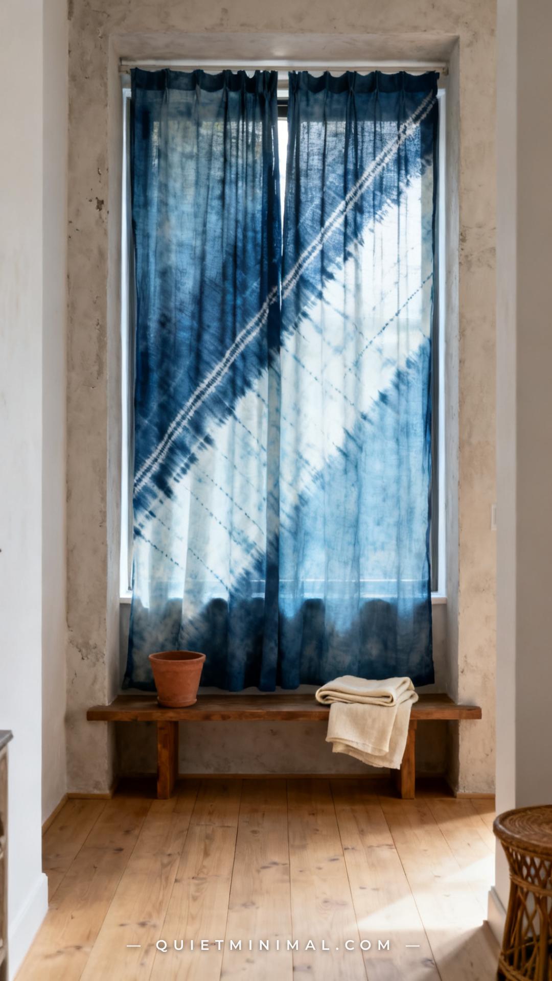 A medium-wide vertical photograph of a full window wall dressed in floor-to-ceiling aged indigo arashi shibori curtain p