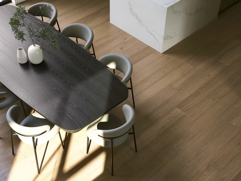 aerial view of dining area with dark-stained oval wood table, cream upholstered chairs with brass legs, pale oak plank f
