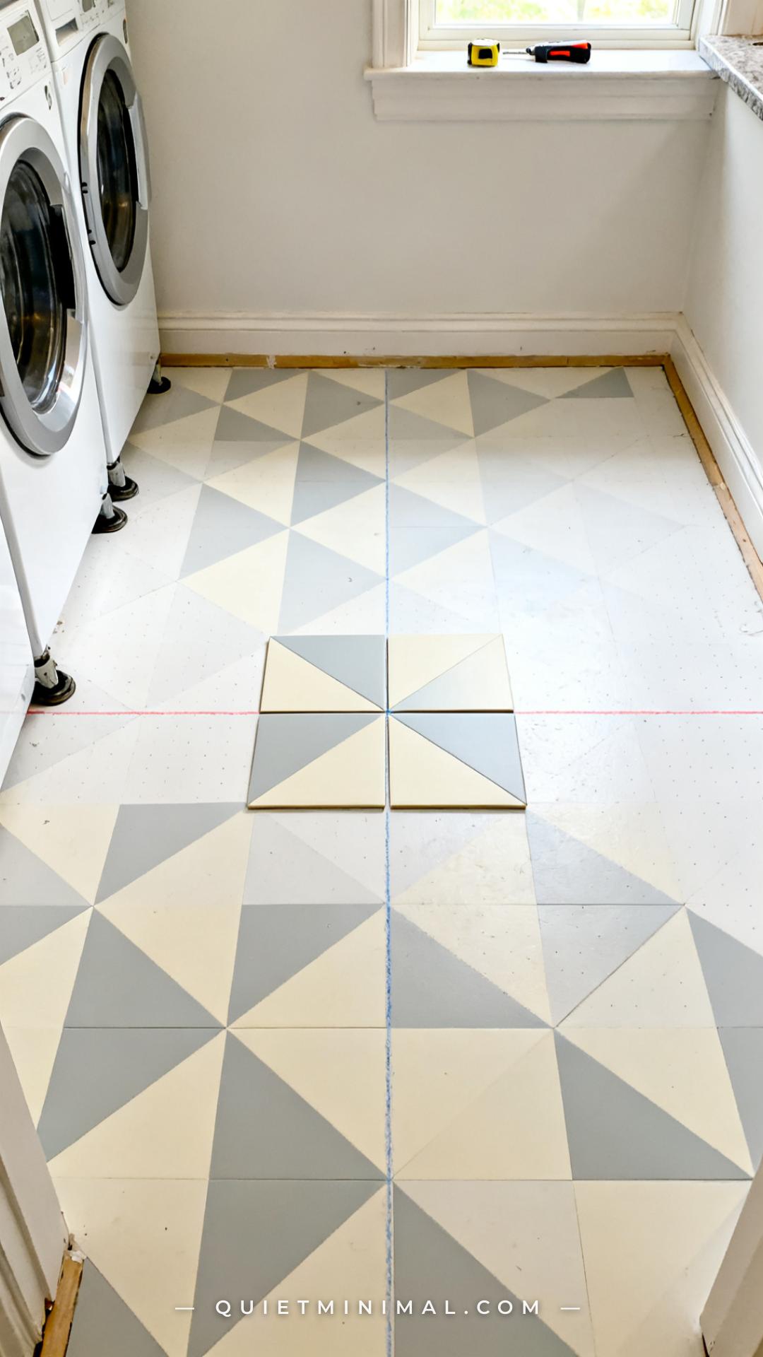 A vertical photograph of a laundry room floor mid-installation