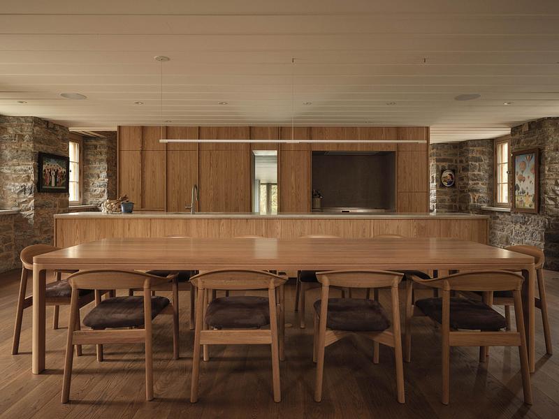 open-plan kitchen and dining room with full-height white oak cabinetry, long oak dining table surrounded by wishbone cha