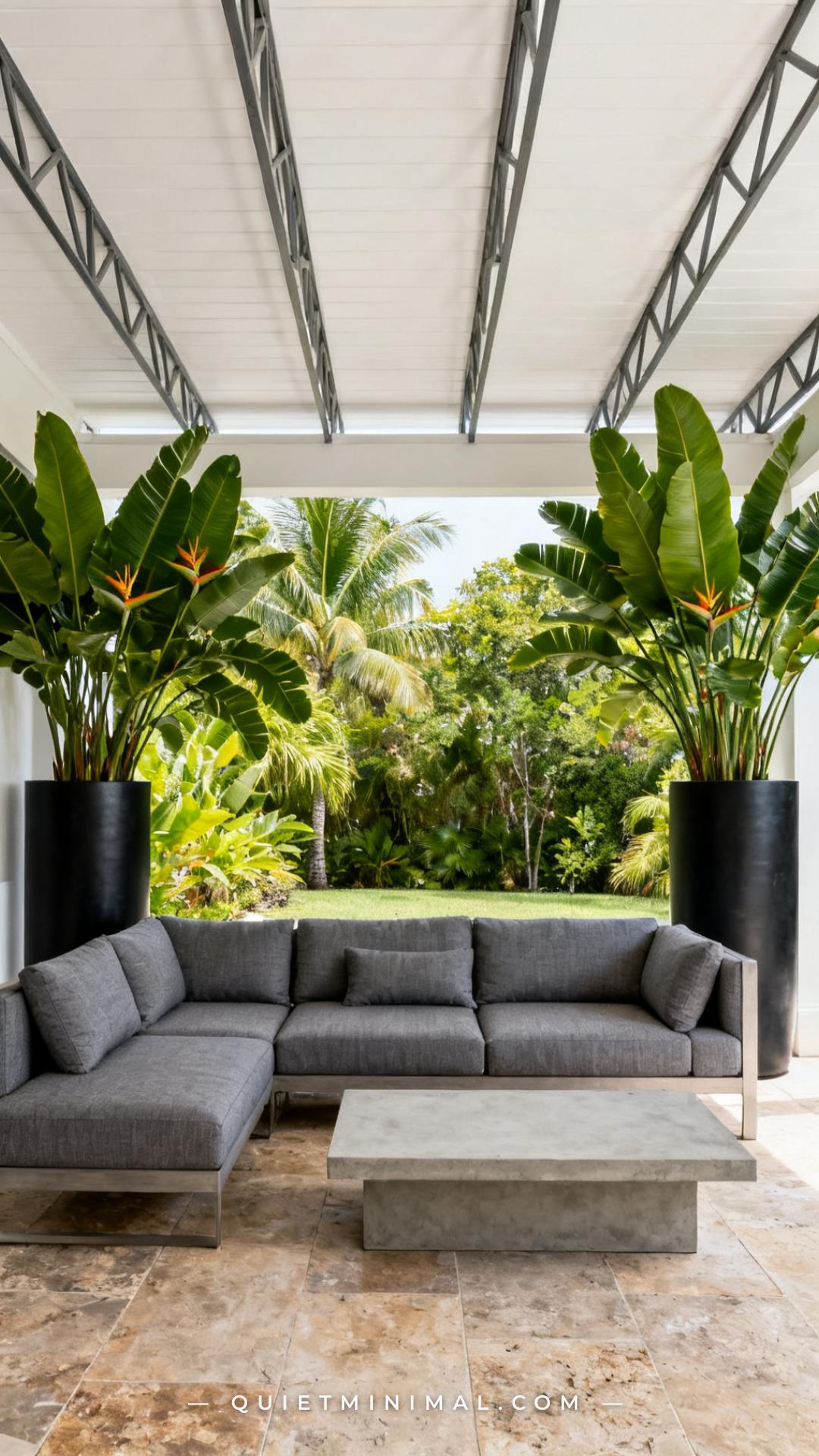A wide establishing shot of a covered patio lounge area showing the back edge of a modular sectional defined by two tall