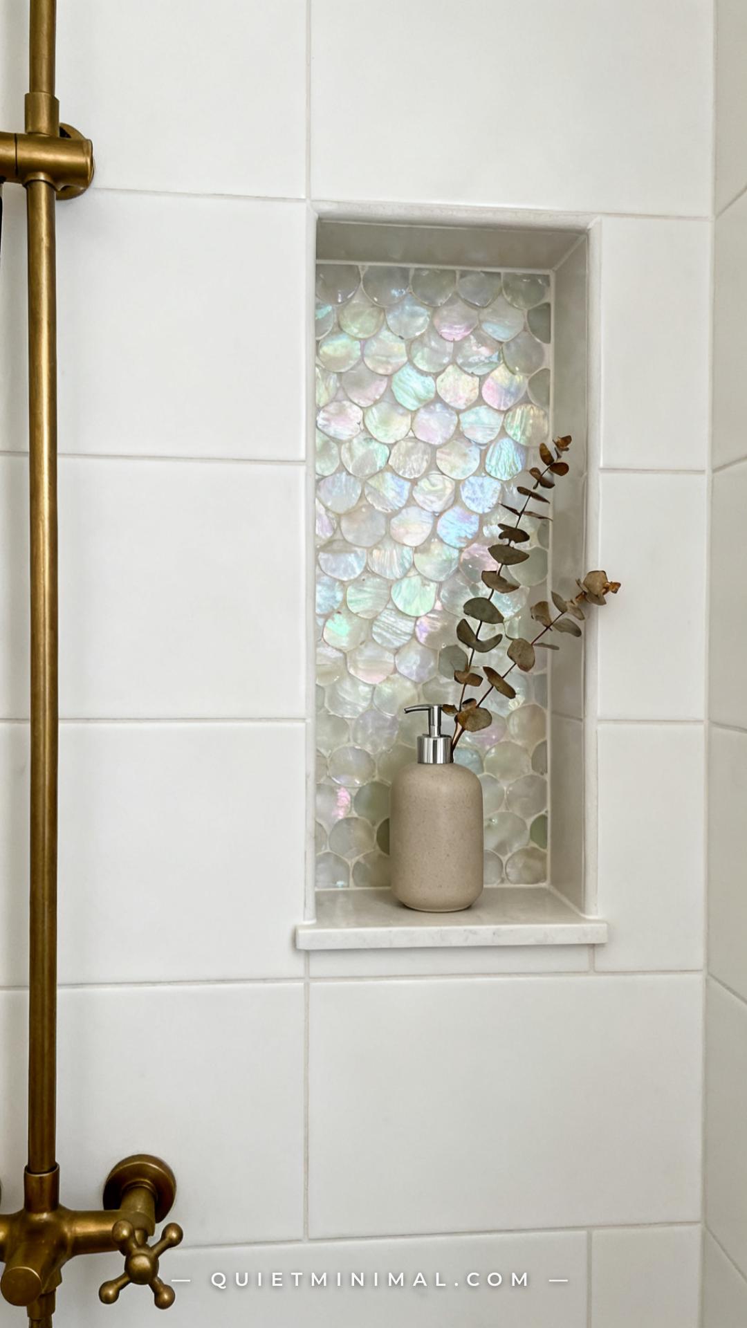 A medium-wide vertical photograph shows a recessed shower niche built into a tiled wall
