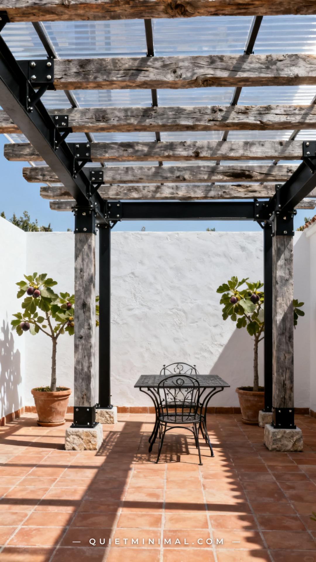 A vertical photograph captures an establishing shot of a pergola constructed with reclaimed oak beams in a weathered gre